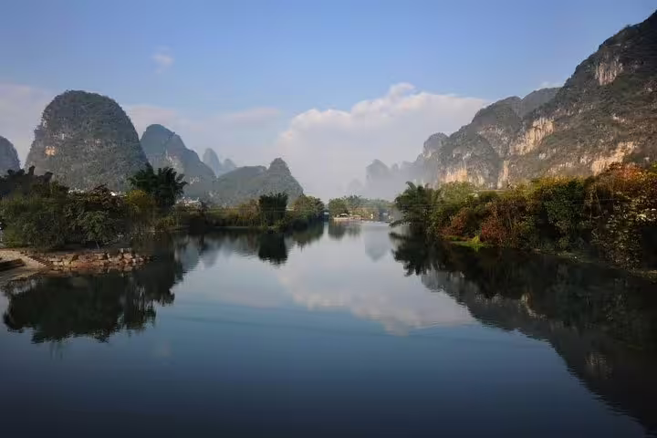 Picturesque Yangshuo landscape with lush greenery and serene river, perfect for an adventurous day tour and boat ride.