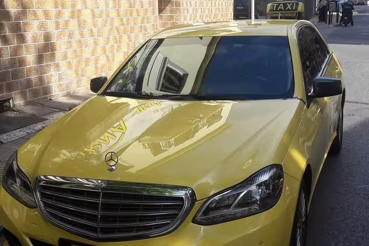 Yellow Mercedes taxi-style sedan for private transfer from Lefkada to Athens, reliable chauffeur service