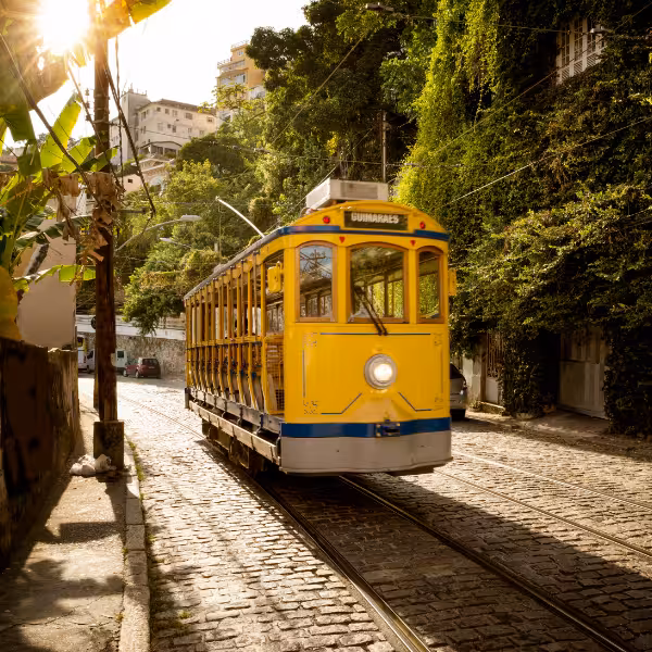 Historic yellow tram navigating the cobblestone streets of Santa Teresa, a charming neighborhood in Rio de Janeiro.
