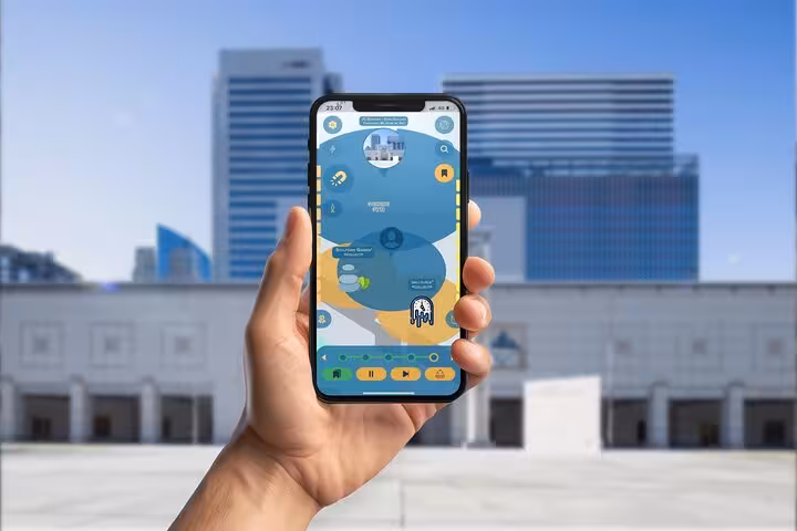 Hand holding smartphone displaying GPS walking tour app map of Yokohama with interactive scavenger hunt icons