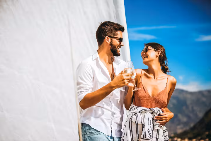 Happy couple enjoying wine and relaxing on a private full-day boat tour under sunny Vilamoura skies