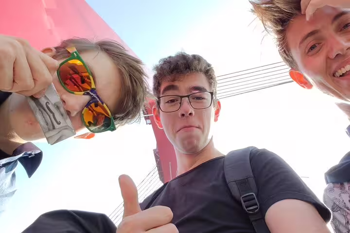 Three young tourists taking a low-angle selfie during a guided walking tour in Rotterdam