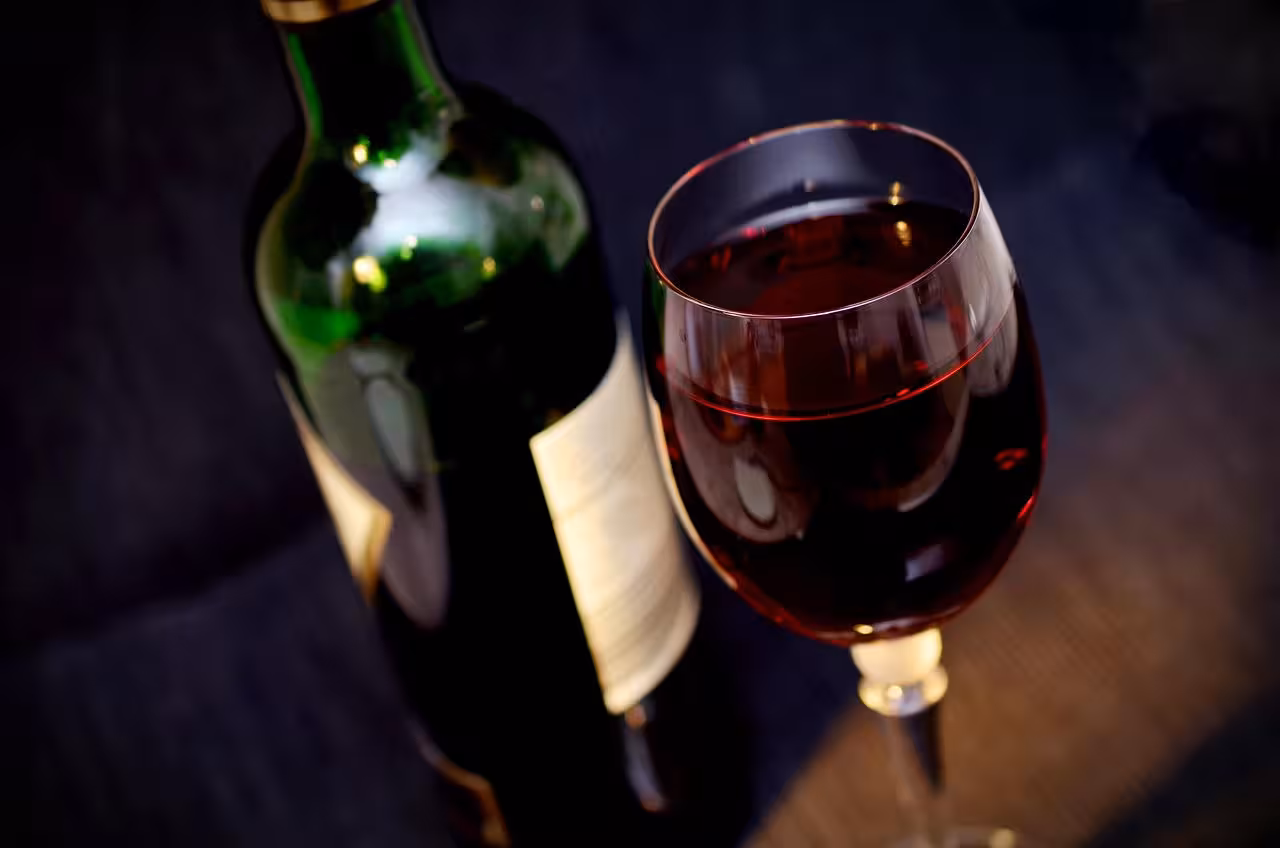 A rich glass of red wine beside a bottle at the Yunquera Wine Festival day trip from Malaga Spain
