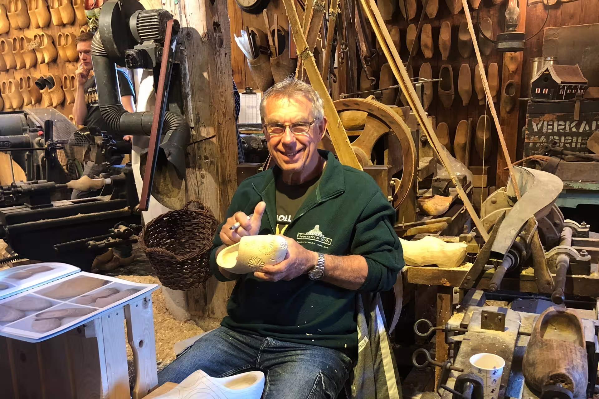 Zaanse Schans clog maker carving wooden shoes in a traditional workshop on Amsterdam day tour