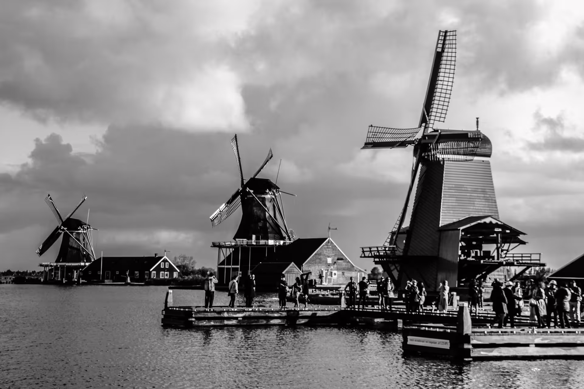 Scenic view of historic Dutch windmills and visitors at Zaanse Schans, highlighting cultural charm on the Netherlands tour.