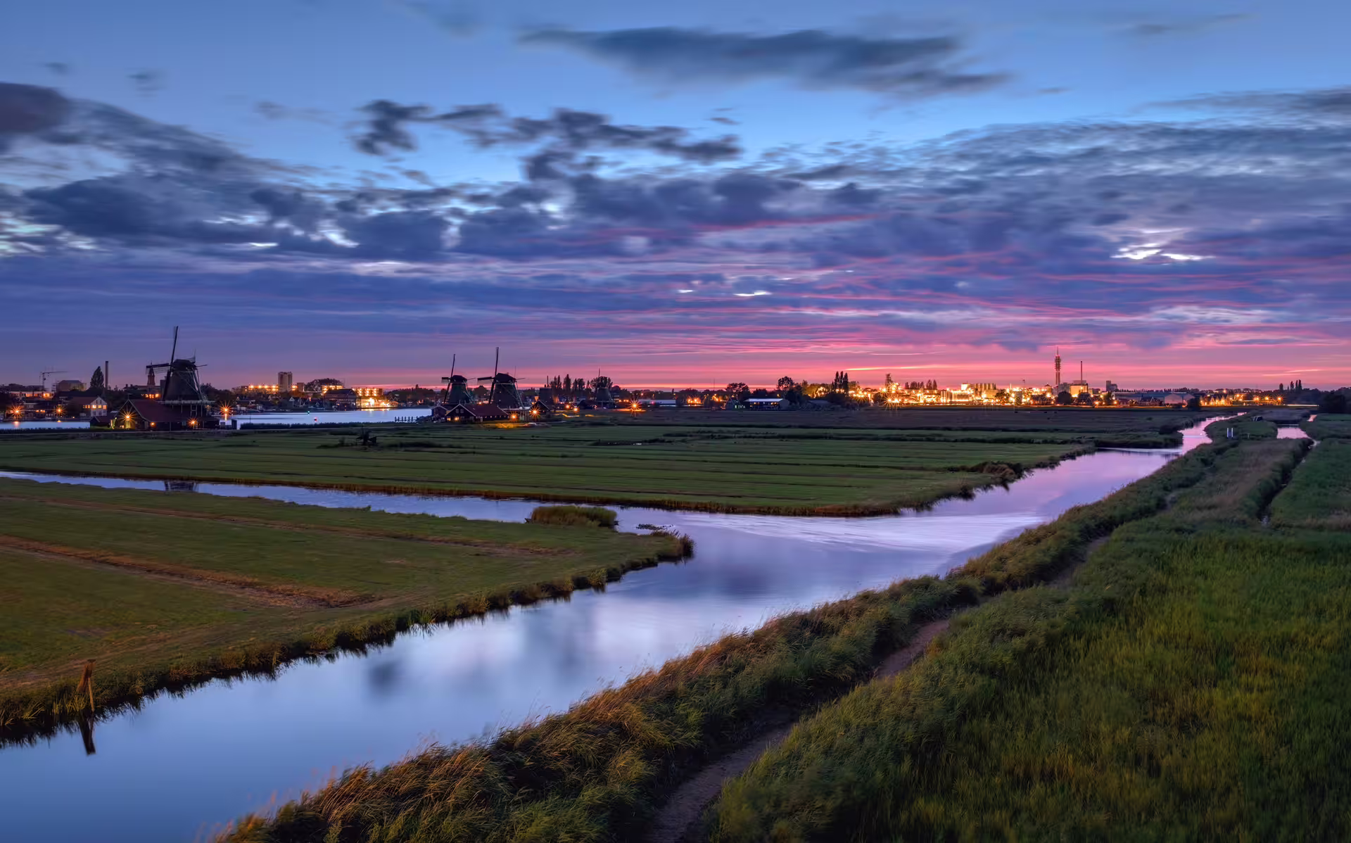 Zaanse Schans at sunset with windmills and canal, perfect for a 1-day walking tour with audioguide