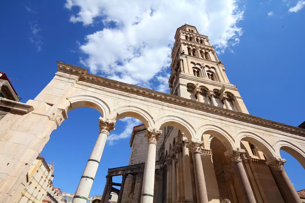 Zagreb city break private tour view of cathedral-style arches and tall stone bell tower under blue sky