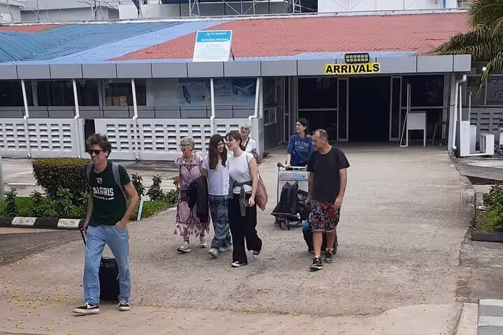 Travelers arriving at Zanzibar airport ready for private 24/7 transfer service to Nungwi hotels, enhancing seamless journey.