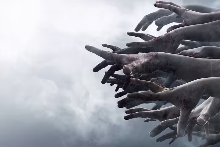 Multiple decayed zombie hands reaching forward through misty fog in a horror scene