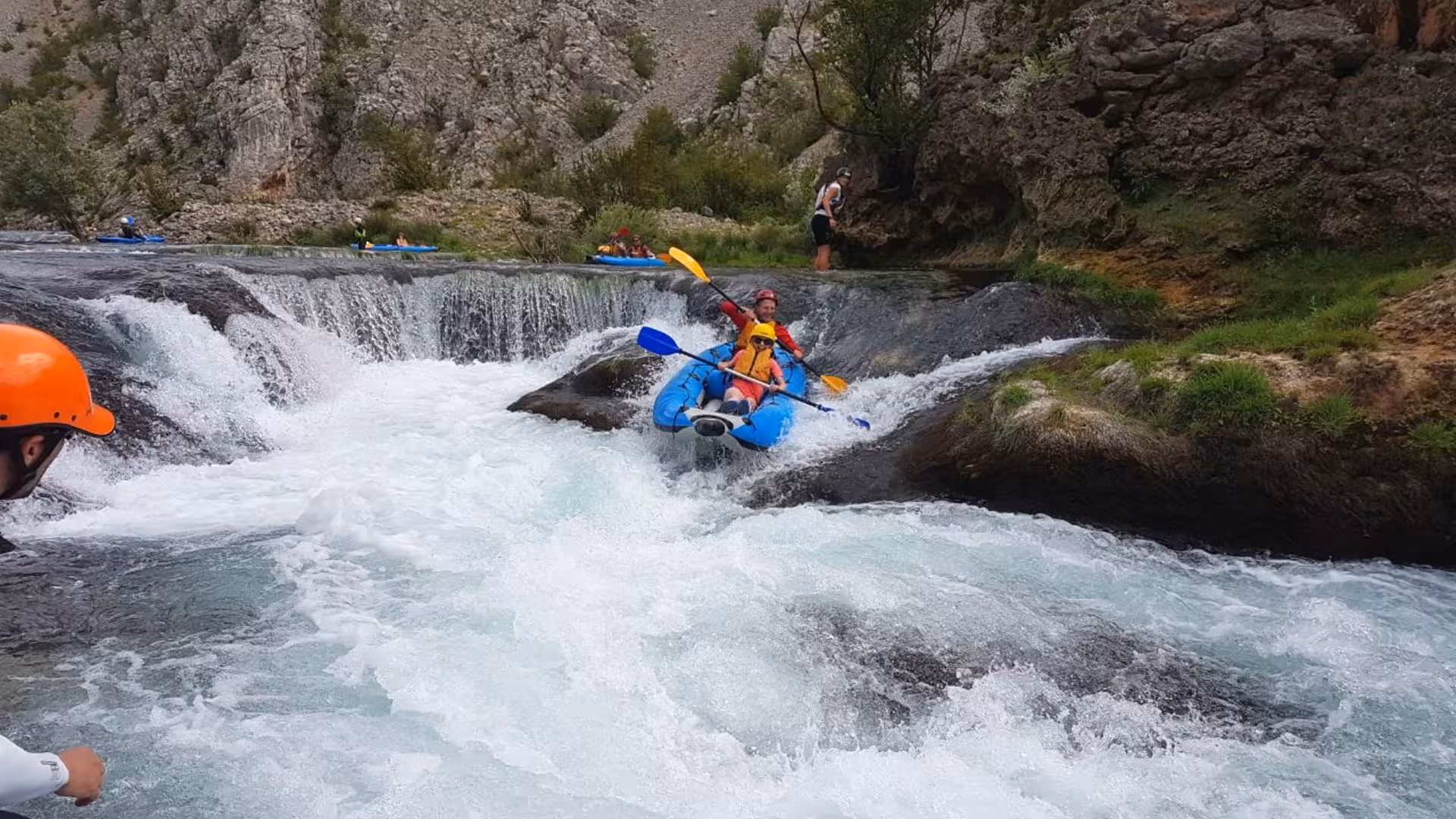 Adult and child going down rapids in a kayak