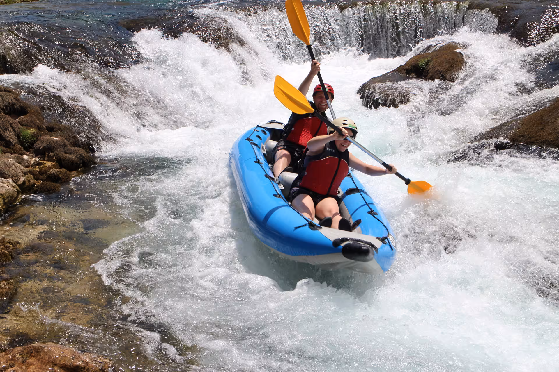Thrilling canoe ride down a small waterfall on Zrmanja River, capturing the excitement and rush of the safari adventure.