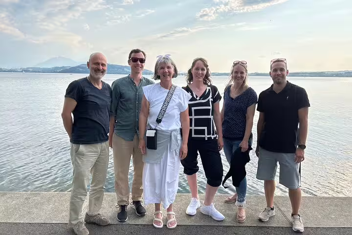 Six friends at Lake Zug promenade on a Zug scavenger hunt and sights self-guided walking tour in Switzerland