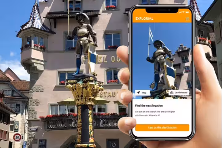 Phone-guided Zug scavenger hunt tour showing historic fountain statue in Old Town with interactive app map