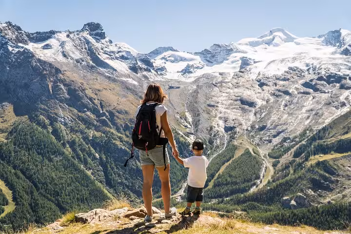 Hiker and child overlooking Saas-Fee glacier valley on Zurich day trip to Allalin revolving restaurant
