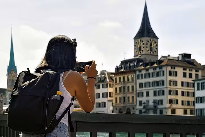 Traveler capturing Zurich's iconic church towers while exploring the city on a private tour.