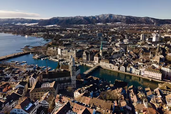 Aerial panoramic view of Zurich old town with river Limmat, lake, and snow-capped mountains in background
