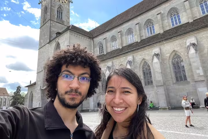 Couple taking selfie in front of Grossmünster church in Zurich on sunny day