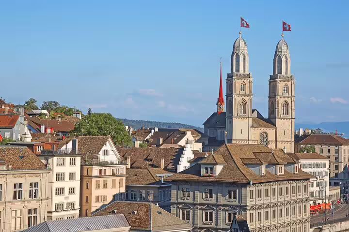 Panoramic view of Zurich's historic Grossmünster towers under a clear blue sky, ideal for cultural exploration.
