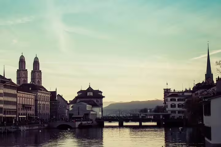 Zurich old town skyline with Grossmünster twin towers and Limmat River at sunset