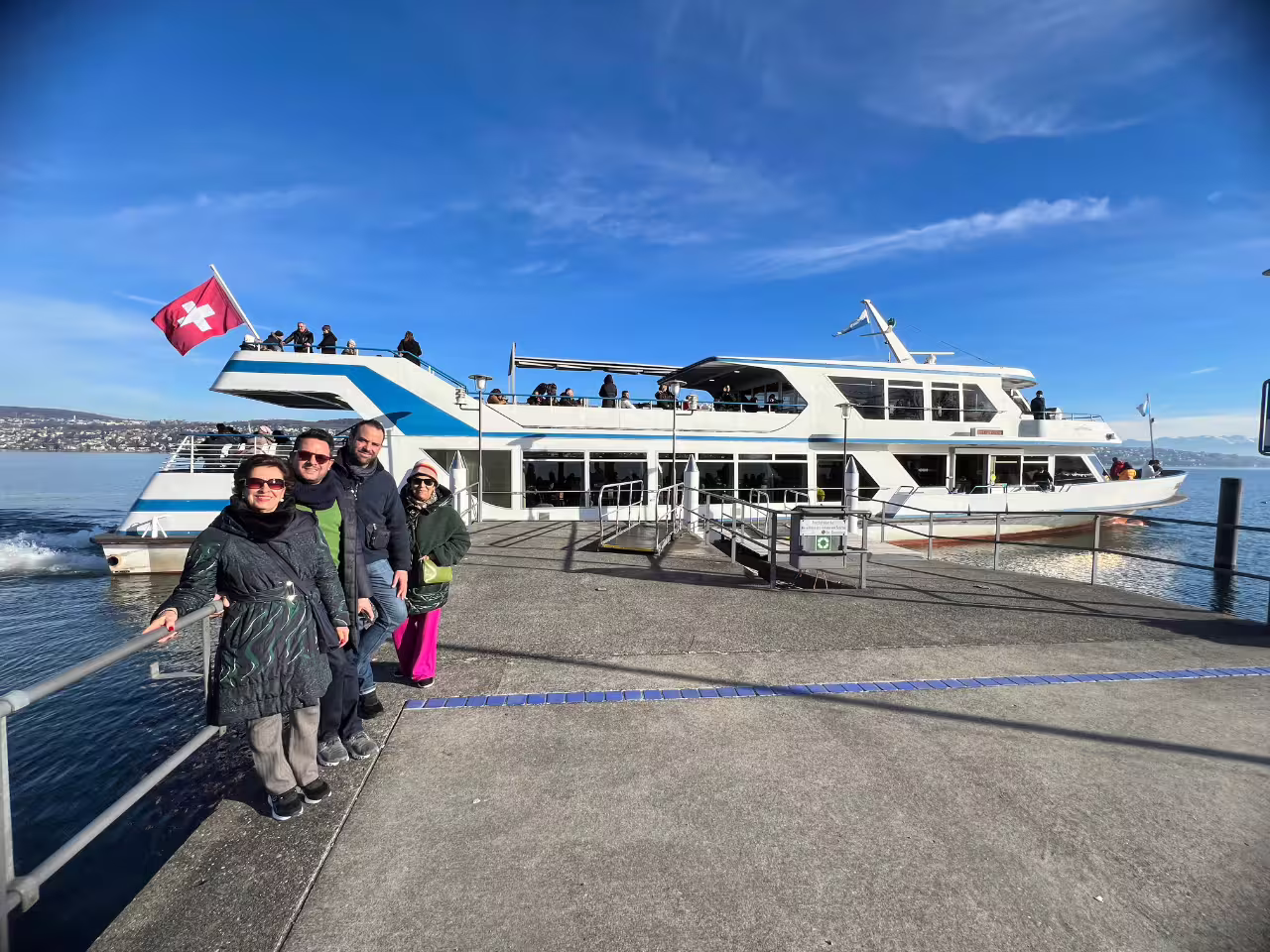 Tourists enjoying a sunny day on a boat docked at Lake Zurich, ready for a half-day private tour.