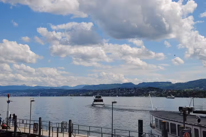 Lake Zurich waterfront with boat and Alpine views, featured on Zurich 360 city walk tour hidden spots