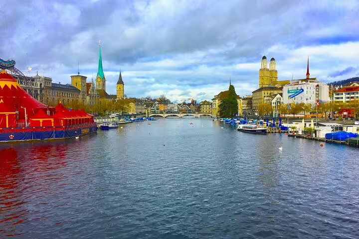 Zurich old town skyline with Fraumünster church spires along the Limmat River with a colorful circus tent