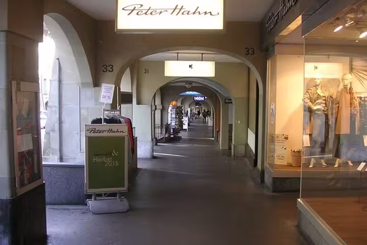 Covered arcade shopping street in Zurich with Peter Hahn store and arched walkway