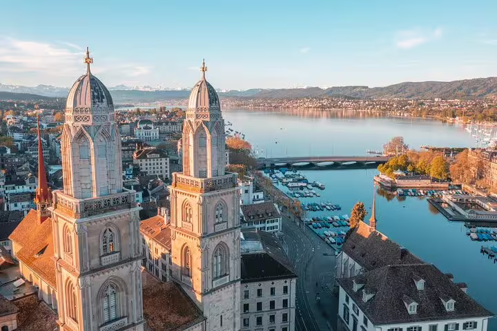 Aerial view of Grossmünster church twin towers overlooking Zurich cityscape and Lake Zurich at golden hour