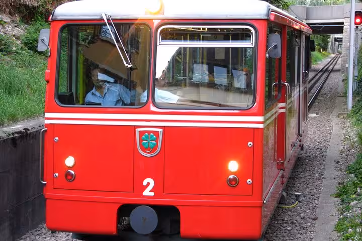 Red cogwheel train on a scenic track in Zurich, offering a unique transportation adventure for tourists.
