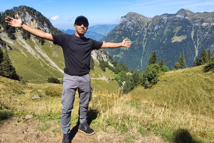 Hiker with arms wide on Rophaien ridge, Swiss Alps scenery above Lake Lucerne on a Zurich day trip tour