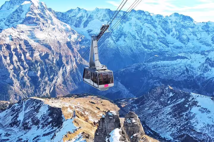 Cable car gondola suspended over snow-capped Swiss Alps mountains near Zürich