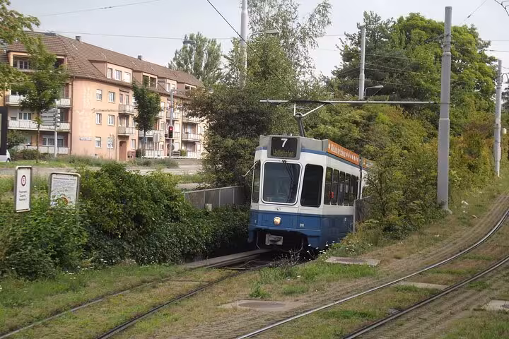 Zurich tram line 7 navigating through lush greenery, showcasing a unique aspect of the transportation adventure tour.