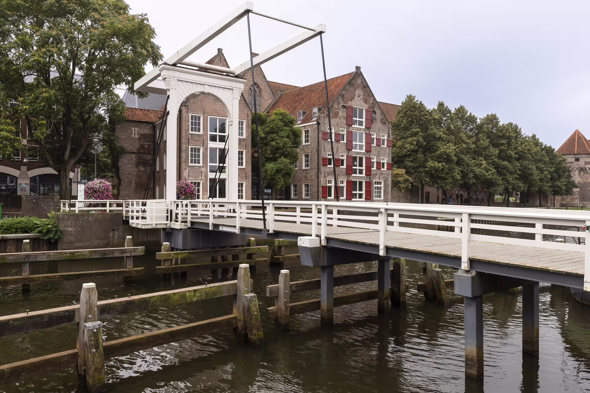 White drawbridge over Zwolle canal by historic brick buildings, key stop on 1-day walking tour audioguide